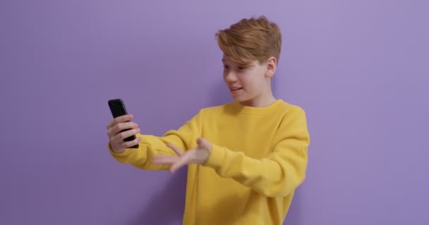 Trevlig kaukasiska tonåring pojke talar på videosamtal med någon, diskutera — Stockvideo