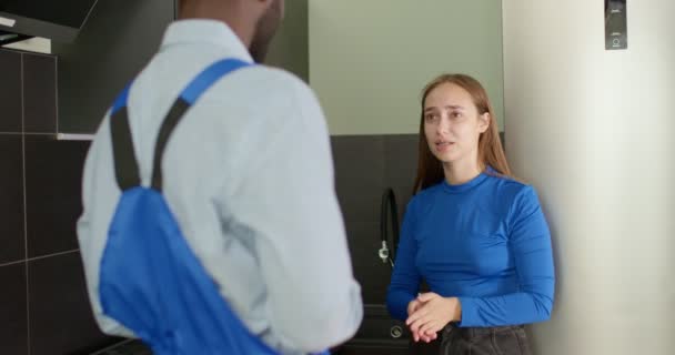 Atraktivní klientka vysvětlující problémy černému pracovnímu instalatérovi — Stock video