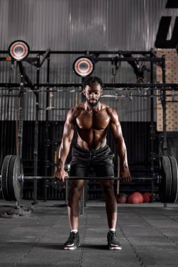 Kas yığını Afrikalı, terli, iri kaslı, ağır halter ağırlıklı bir adam.