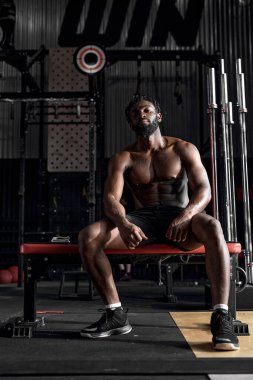 Dark-skinned African Man Sit Having Rest, Relaxed After Intense Cross Fit Training In Gym