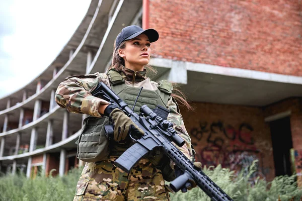 Mulher militar confiante com arma no campo, feminino em terno de camuflagem — Fotografia de Stock