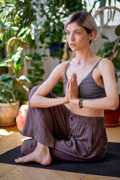 Young caucasian woman practicing mindfulness yoga at home keeping hands together — Stok fotoğraf