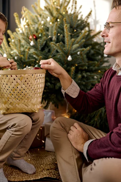 Папа и сын вместе украшают елку накануне праздников. семейная концепция — стоковое фото