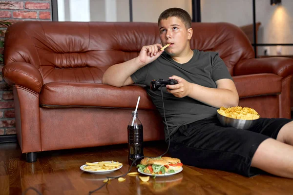 Grasso sovrappeso adolescente ragazzo ha cattiva alimentazione, mangiare cibo malsano — Foto Stock