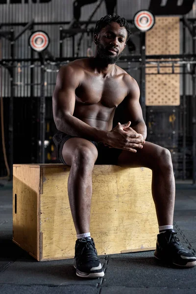 Cansado y agotado afroamericano hombre se sienta en madera cruz ajuste caja relajante —  Fotos de Stock
