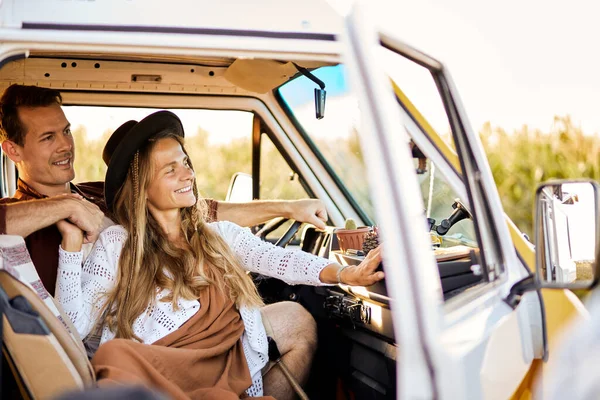 Concetto di stile di vita hippie e di viaggio. felice signora e uomo rilassante all'interno del furgone retro tronco — Foto Stock