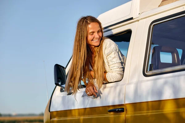 Adventurous soul. Attractive young smiling woman leaning out the vans window — Stock Photo, Image