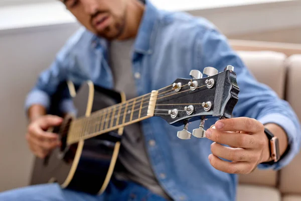 Barbu homme tuning guitare acoustique à la maison, jeune guitariste fixation tuning chevilles close-up — Photo