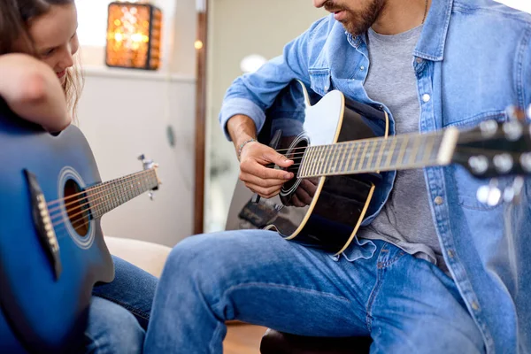 Крупным планом мужчина и милая девочка играют на гитаре — стоковое фото