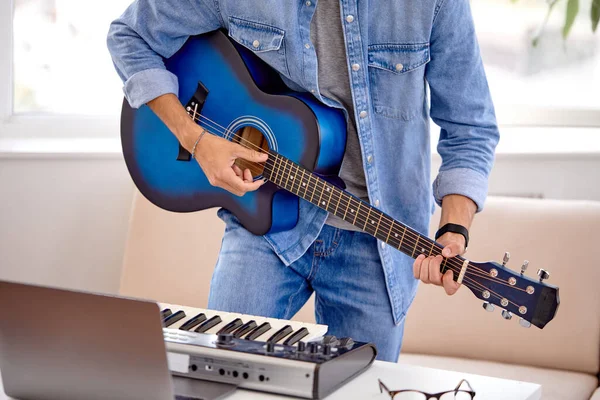 Cropped Man en jean jouant de la guitare acoustique, à l'aide d'un ordinateur portable, interprète de la musique — Photo