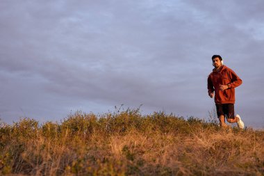 Gün batımı ve koşan adam saha eğitiminde, koşuyor. Sağlıklı yaşam tarzı kavramı