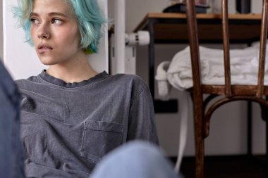 Mutsuz, üzgün bir kadın yerde tek başına oturuyor. Yalnızlıktan rahatsız, üzgün.