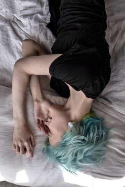 Stresli, üzgün bir kadının yatakta çaresizce yatması. İnsani duygular