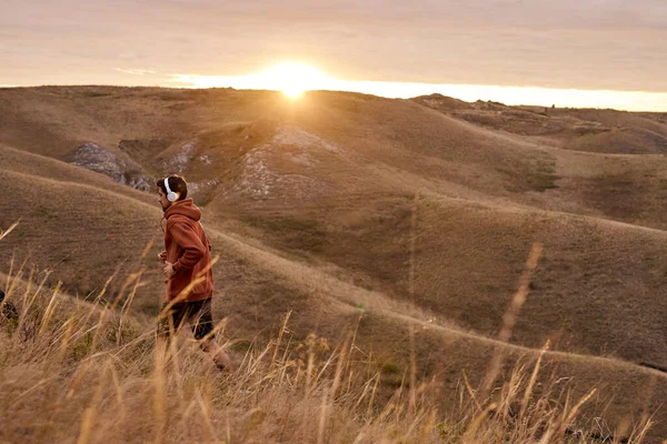 Laufen Mann bei Sonnenuntergang feurigen Himmel Hintergrund in den Bergen, Sport und Erholung — Stockfoto