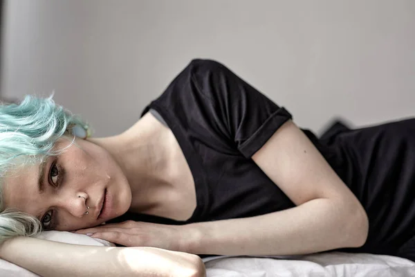 Jovencita acostada en la cama con dolor, con calambres menstruales. deprimida mujer solitaria — Foto de Stock
