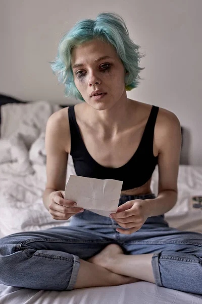 Vrouw gaat zelfmoord plegen huilend over het lezen van brief, zittend op bed — Stockfoto