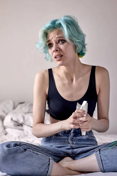 Kobieta siedząca na łóżku z listem. depresja, trudności w relacjach, migrena — Zdjęcie stockowe