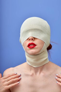 Büyük kırmızı dudaklı, başı ve boynu bandajlı, tanınmayan bir kadın.