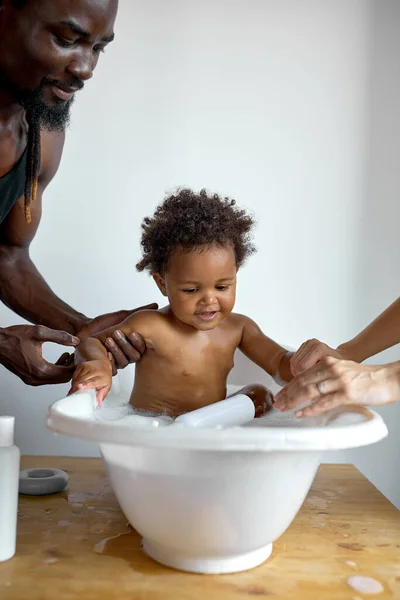 Το μικρό παιδί κάνει μπάνιο. Οι γονείς κάνουν μπάνιο το μωρό. Όμορφο μωρό. οικογένεια στο σπίτι — Φωτογραφία Αρχείου