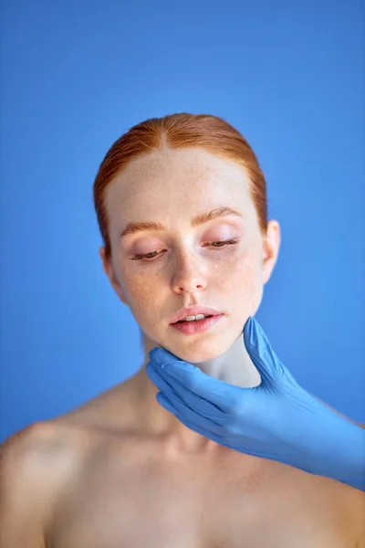 Derma femminile ringiovanire il trattamento. Dottore in guanti toccare rossa faccia donna. — Foto Stock