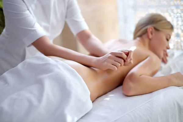 Гарненька жінка насолоджується розслабляючим масажем спини в косметологічному спа-центрі — стокове фото