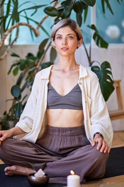 Kısa saçlı kadın evde yoga egzersizi yapıyor, yerde oturuyor. Farkındalık meditasyonu — Stok fotoğraf