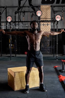 Spor salonuna gitmeden önce omzunu esneten sağlıklı bir Afrikalı. Fitness güçlü erkek atlet