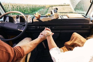 Sürücü ve kız arkadaşının kollarını tutarken çekilmiş yüksek açılı yakın çekim.