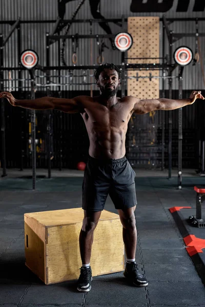 Hombre africano saludable estirando el hombro antes del entrenamiento de gimnasia. Fitness atleta masculino fuerte —  Fotos de Stock