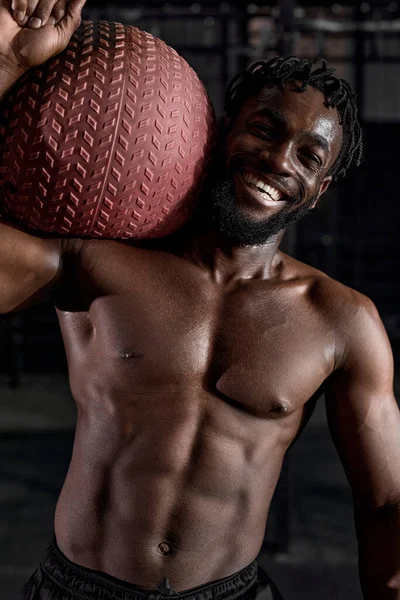 Afro Fitness homem trabalhando fora em ambientes fechados ginásio moderno usando bola medicina. — Fotografia de Stock
