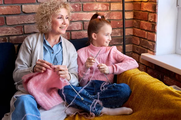 Oma en meisje breien. senioren vrouw onderwijzen klein meisje te breien. — Stockfoto