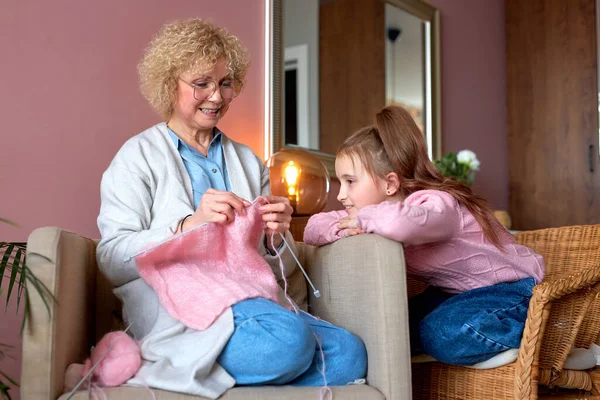 Grootmoeder tonen dochter hoe te breien van garen zitten in de slaapkamer — Stockfoto