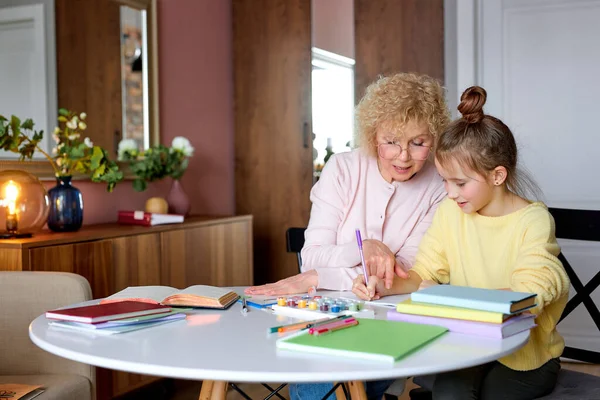 Blanke vrouw tijd doorbrengen met dochter tekenen en huiswerk maken — Stockfoto