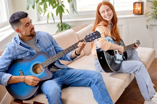 Уверенный стильный мужчина и красивая женщина играют на гитаре — стоковое фото