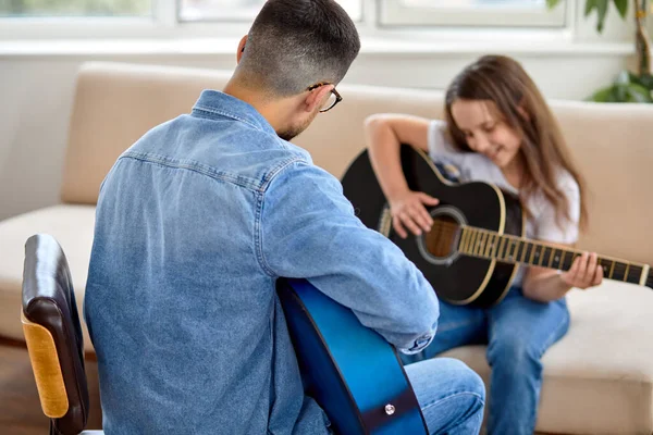 Vue arrière sur Nice professeur masculin expliquant à l'enfant les bases de jouer de la guitare — Photo