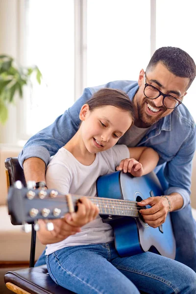 Jolie adolescente recevant des leçons de guitare par un beau mec, montrant comment jouer — Photo