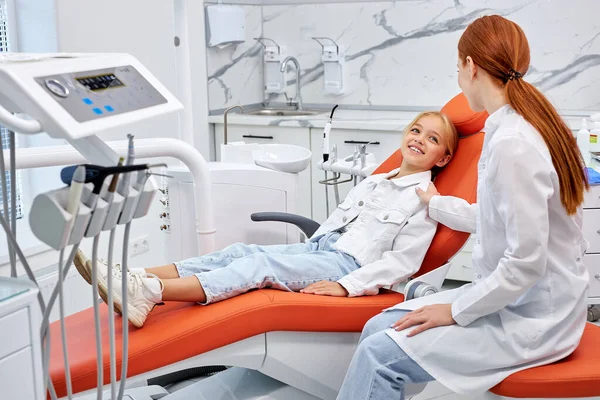 Glad liten barn flicka i tandkirurgi väntar på undersökning soffa — Stockfoto