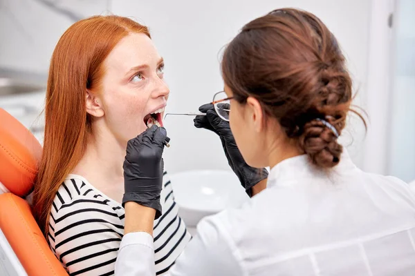 Όμορφη κοκκινομάλλα Γυναίκα ασθενής με όμορφο χαμόγελο εξετάζεται οδοντιατρική επιθεώρηση — Φωτογραφία Αρχείου