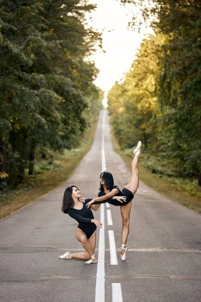 Dvě baletky dámy cvičení společně v lese ve večerních hodinách, provedení tanec — Stock fotografie