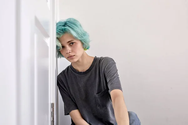 Femme triste avec les cheveux verts assis sur le sol appuyé sur le mur, l'air déprimé et bouleversé — Photo