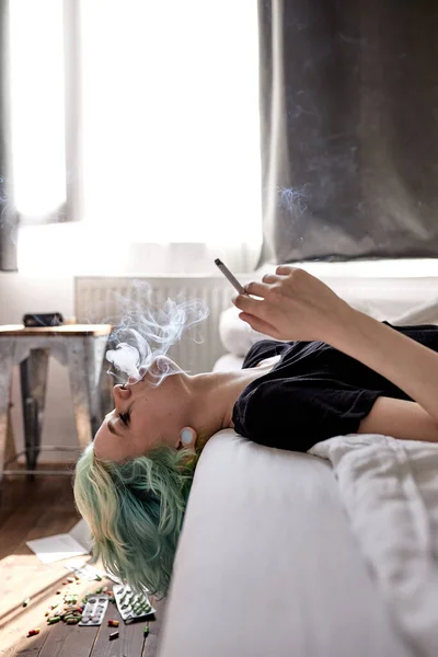 Stresszes nő fekszik otthon az ágyon, sír, dohányzik. idegi feszültségtől szenved — Stock Fotó