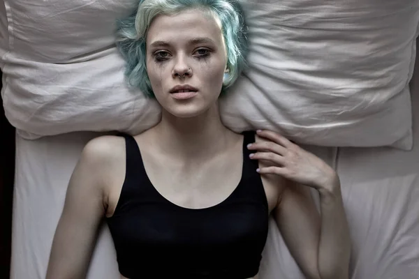 うつ病の概念。動揺した白人女性がベッドに横になって泣き — ストック写真