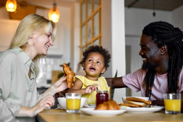 Збуджена молода сім'я поснідала разом за столом на сучасній кухні, любов — стокове фото