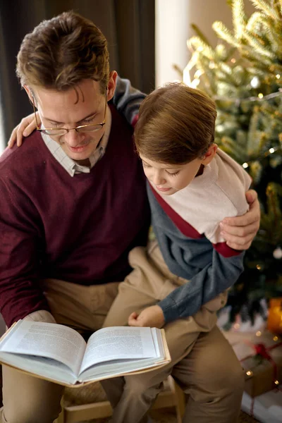 Папа и сын читали книгу. прекрасный семейный отдых на дому, ребенок сидеть спокойно с родителями — стоковое фото