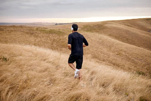 Fit Typ Sprinter, der in Sportbekleidung auf dem Feld läuft. Sport- und Fitness-Motivation — Stockfoto