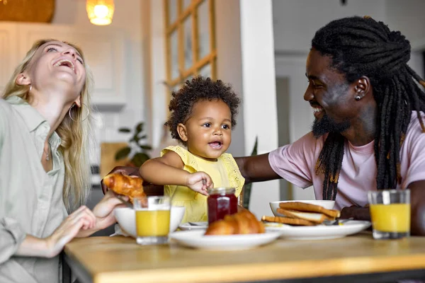 Ευτυχισμένη νεαρή οικογένεια παίρνει πρωινό μαζί στο τραπέζι στη σύγχρονη κουζίνα, την αγάπη — Φωτογραφία Αρχείου