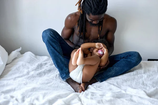 Χαρούμενος μαύρος πατέρας αγκαλιάζει νεογέννητο μωρό. αξιολάτρευτο νεογέννητο μωρό στα χέρια του μπαμπά. — Φωτογραφία Αρχείου