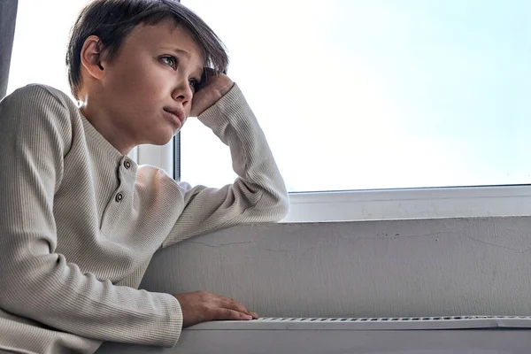 Ragazzo dell'adolescenza è a casa appoggiato sul davanzale della finestra e guarda al futuro — Foto Stock