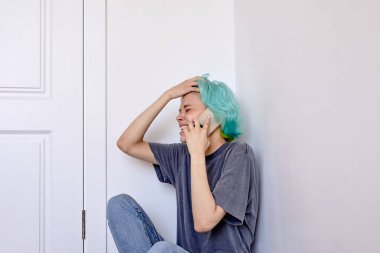 Depresyondaki mutsuz, yalnız bir kadın telefonda konuşuyor.