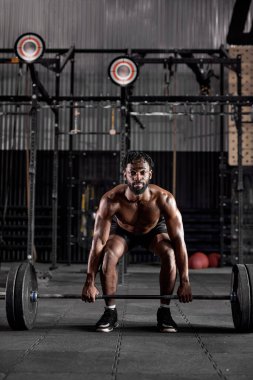 Kendine güveni olan havalı, güçlü bir Afrikalı erkek. Ekipman tutuyor.